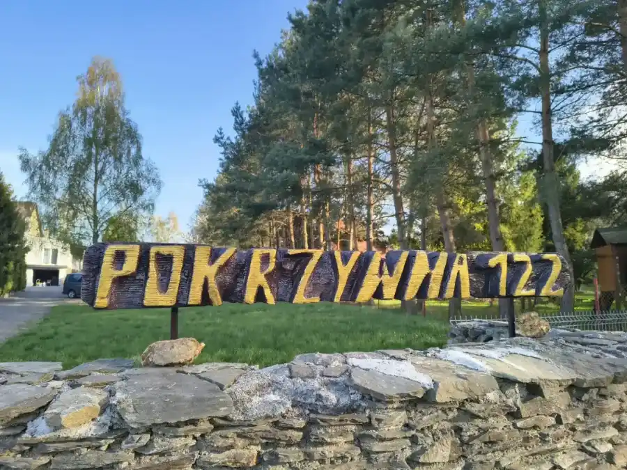 Drewniany szyld Pokrzywna 122 przed Art Villą
